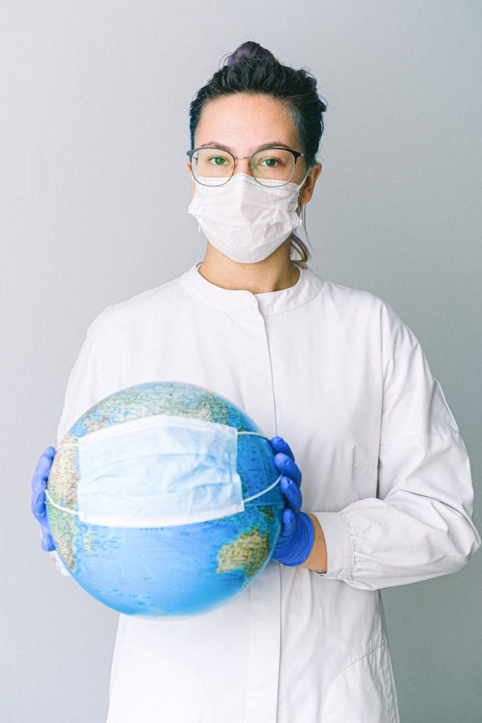 Conceptual image of a doctor holding a globe with a mask, symbolizing global health.