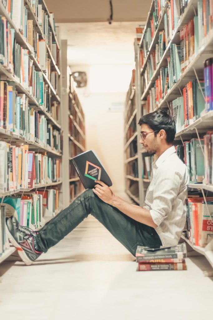 man reading book on the library. visa de estudiante para España